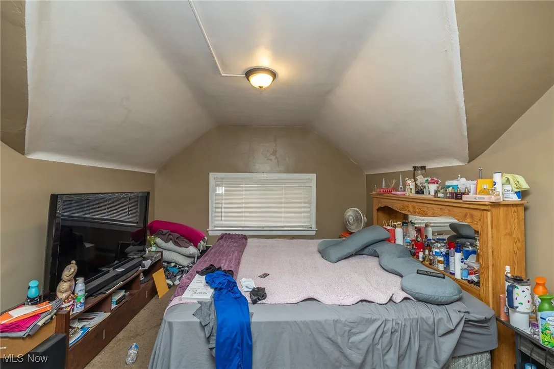 Carpeted bedroom featuring vaulted ceiling