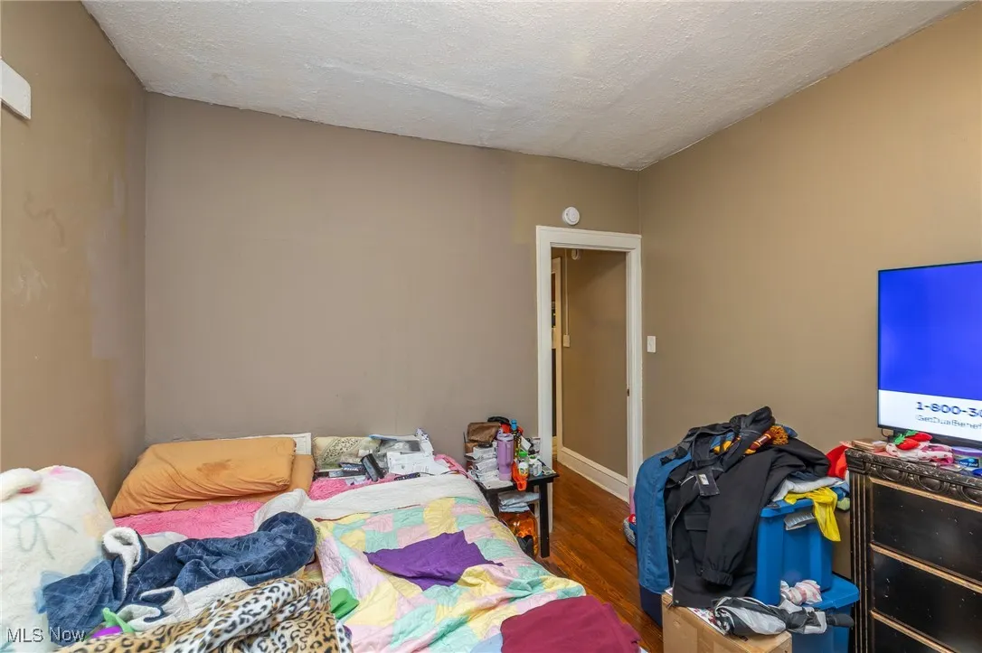 Bedroom with dark wood-style flooring and a textured ceiling