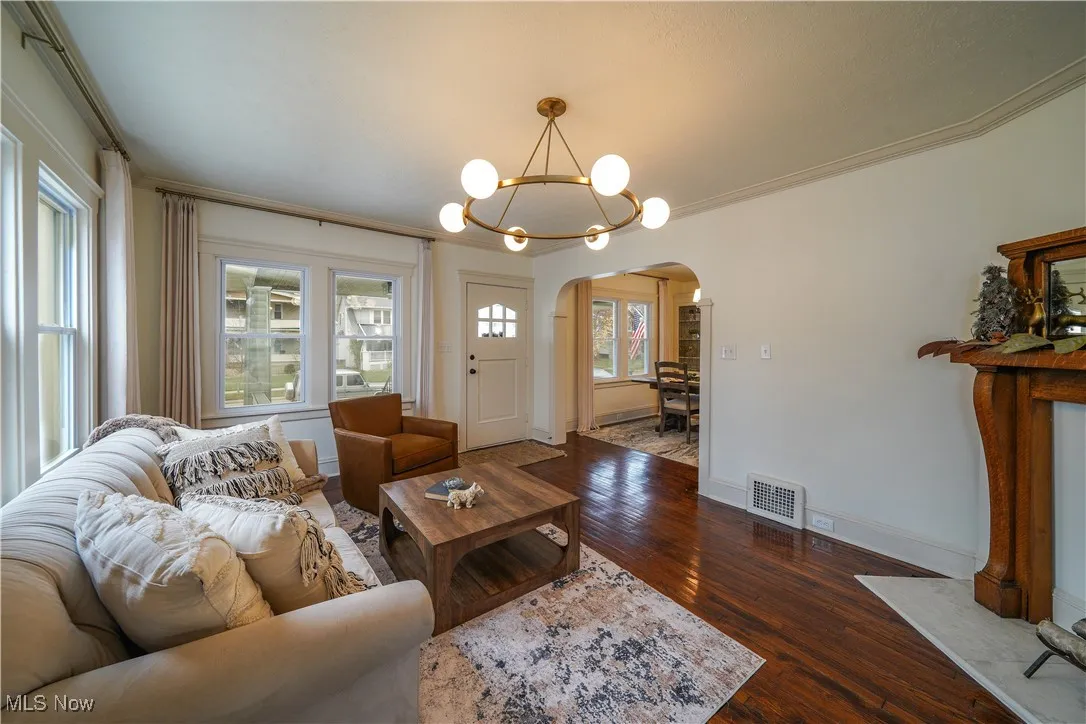 Living room with restored hardwood floors, new windows and lighting.