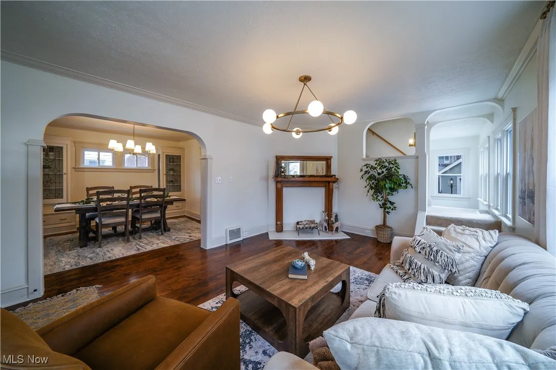 Living room and dinning room with restored hardwood floors and new lighting