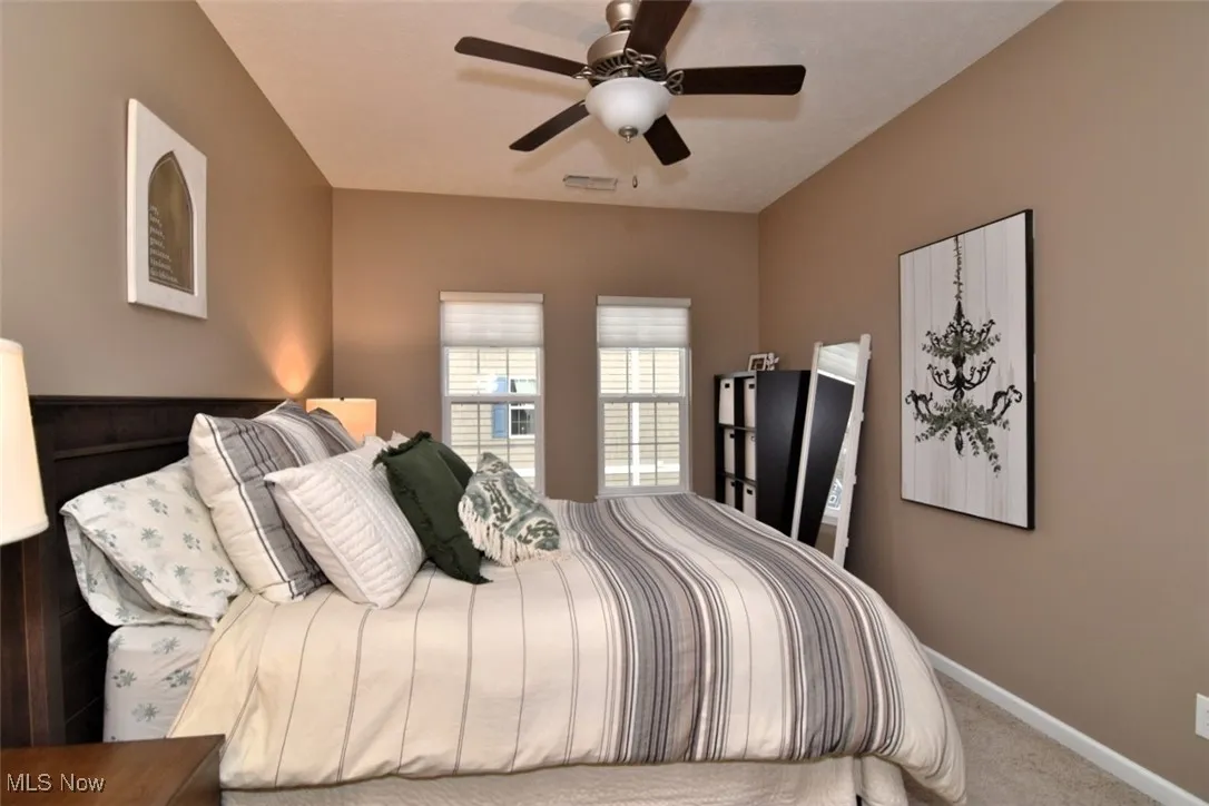 Carpeted bedroom with baseboards and ceiling fan