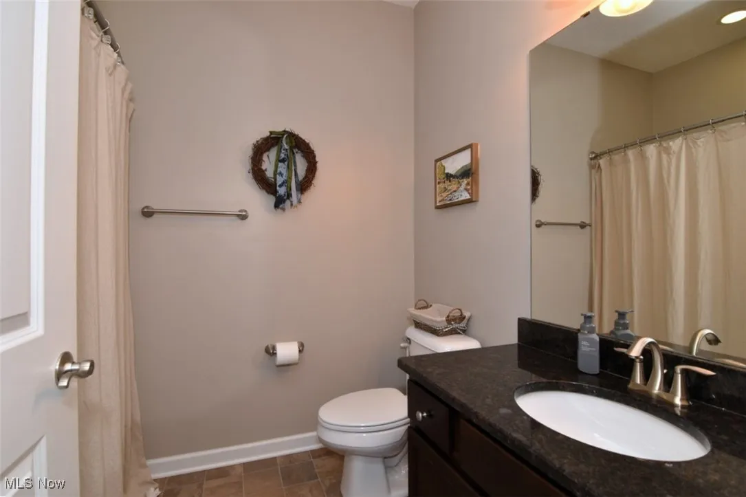 Bathroom with a shower with curtain and vanity
