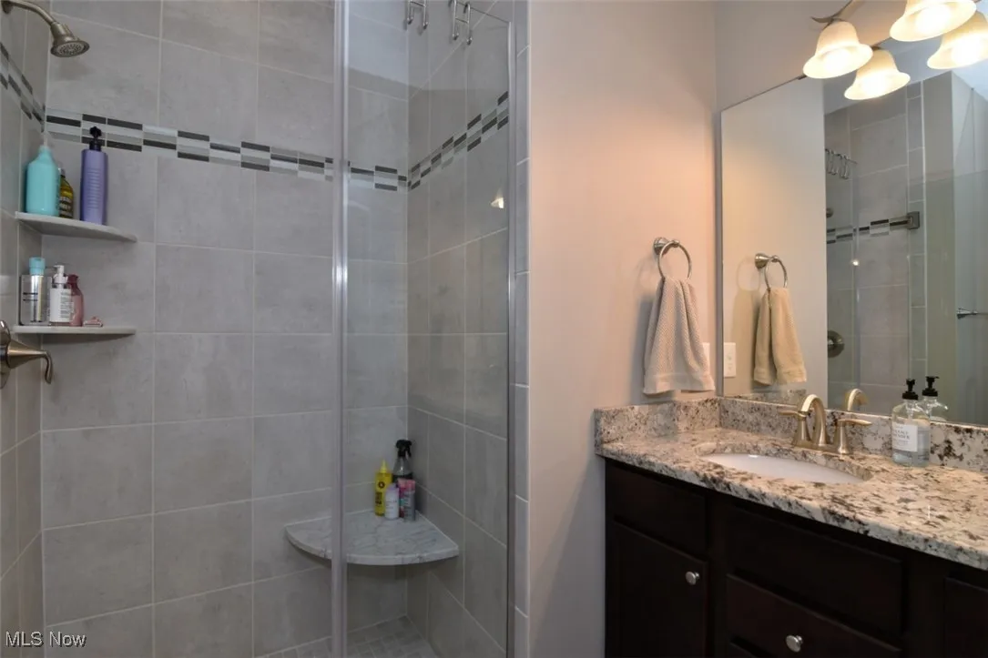 Full bathroom with vanity and a shower stall