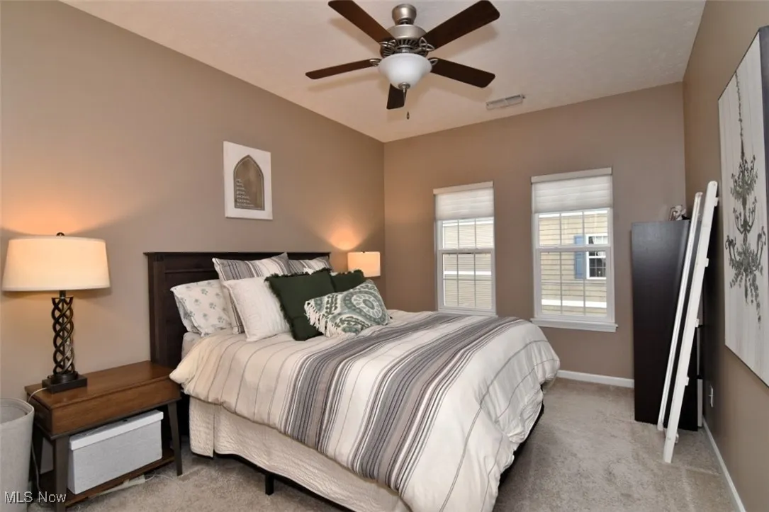 Bedroom featuring light carpet and a ceiling fan