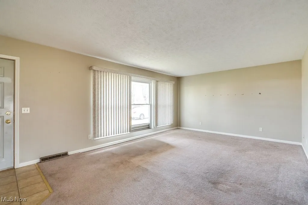 Unfurnished room featuring carpet floors and a textured ceiling