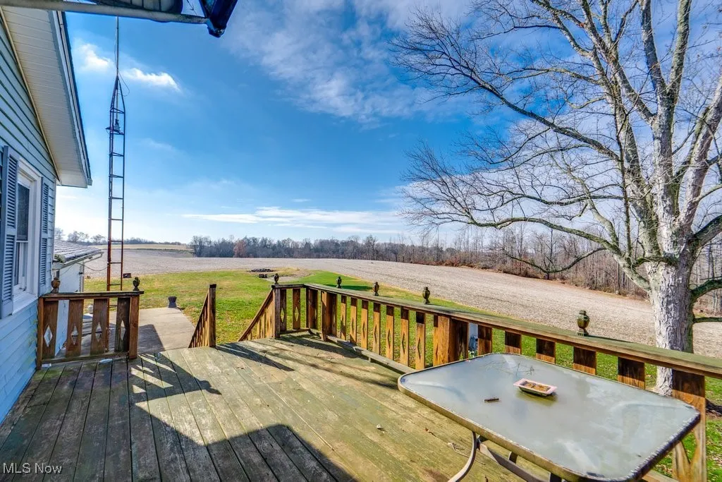 Wooden terrace with a rural view and a lawn