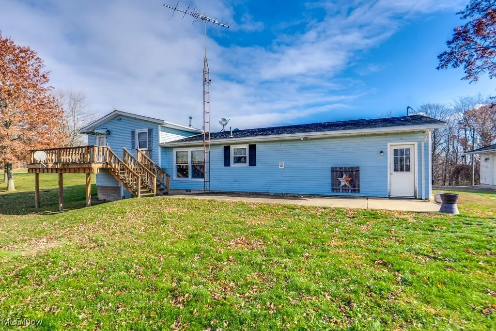 Rear view of property featuring a patio, stairway, a lawn, and a deck