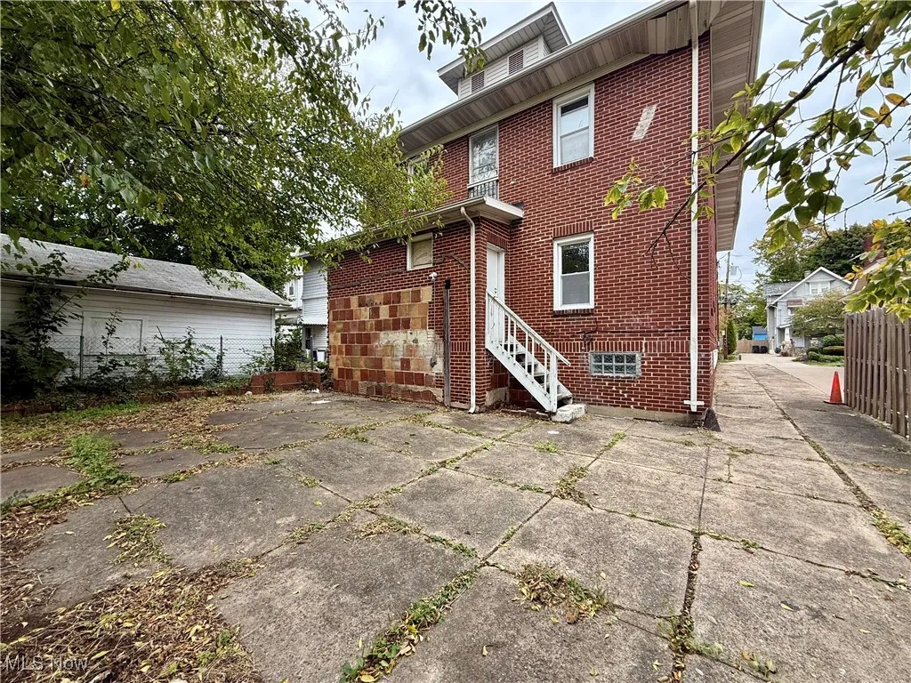 Rear view of property with brick siding