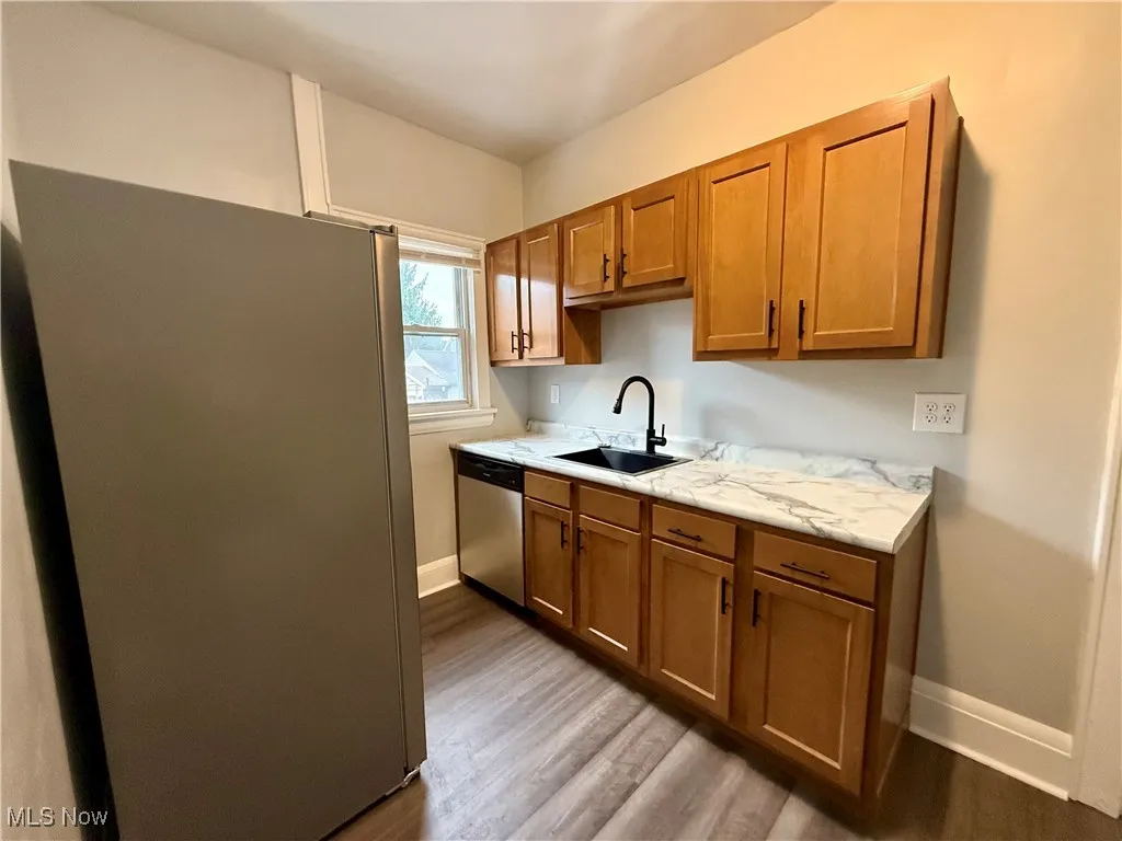 Kitchen featuring stainless steel appliances, brown cabinets, and light wood-style floors