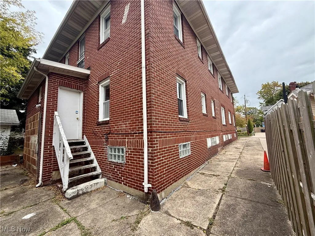 View of side of home featuring brick siding and entry steps