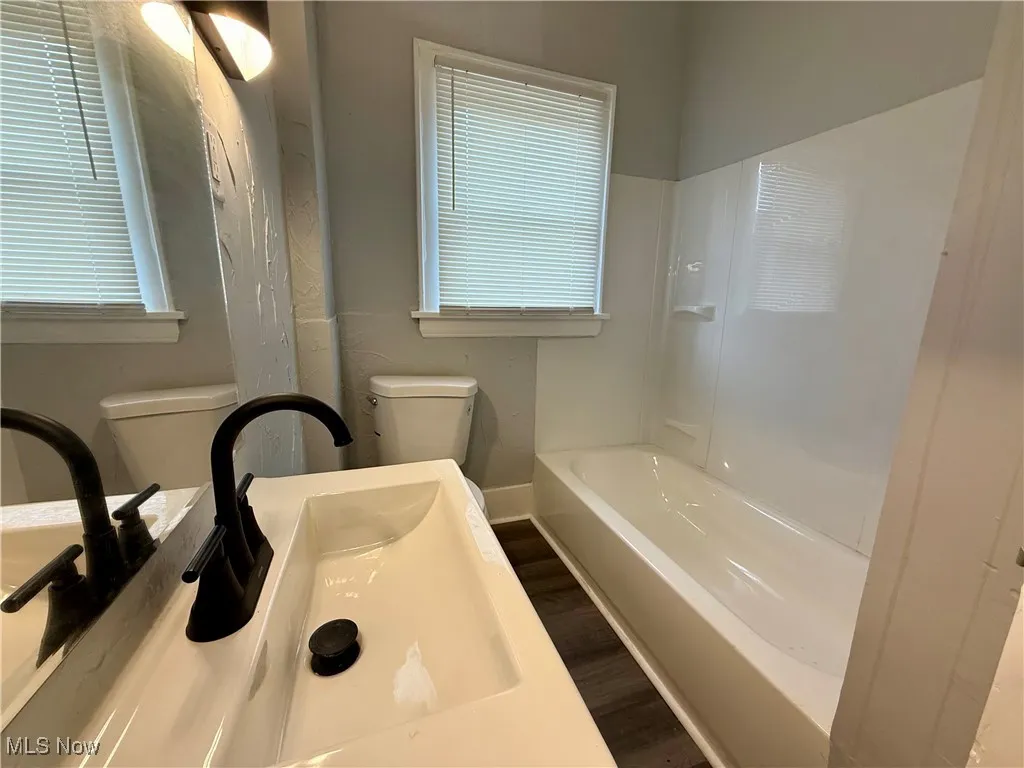 Full bath featuring dark wood-style flooring and vanity