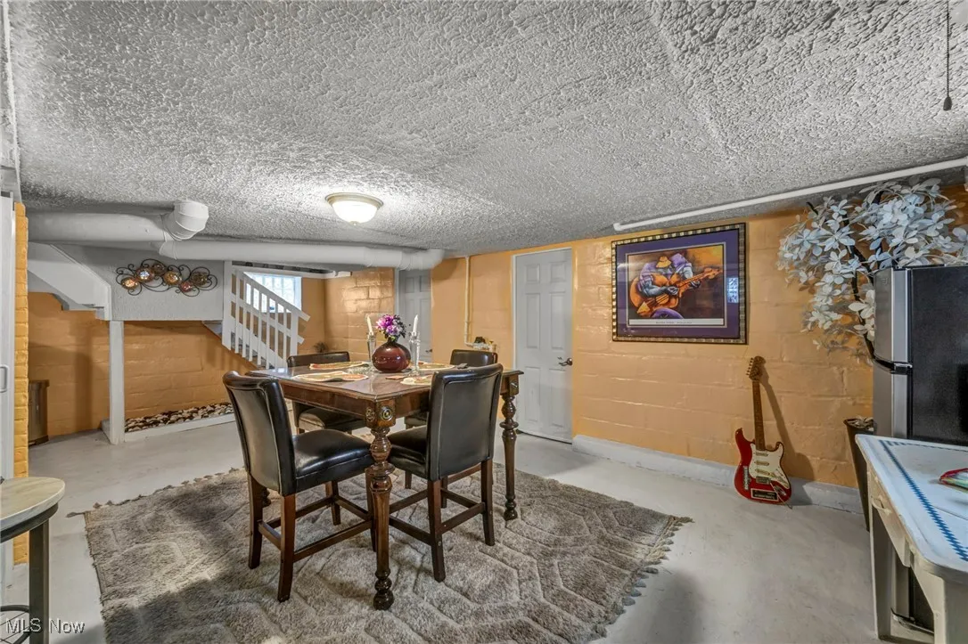 Dining area featuring stairs and concrete flooring