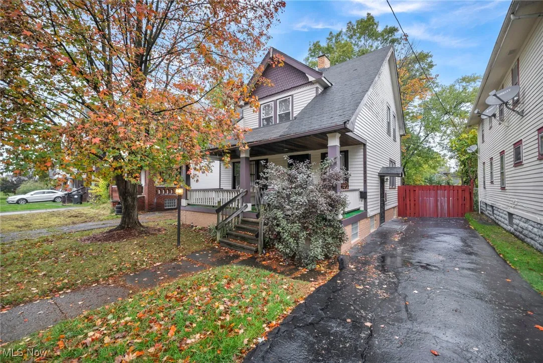 View of front of house featuring a chimney, a porch, a shingled roof, and driveway