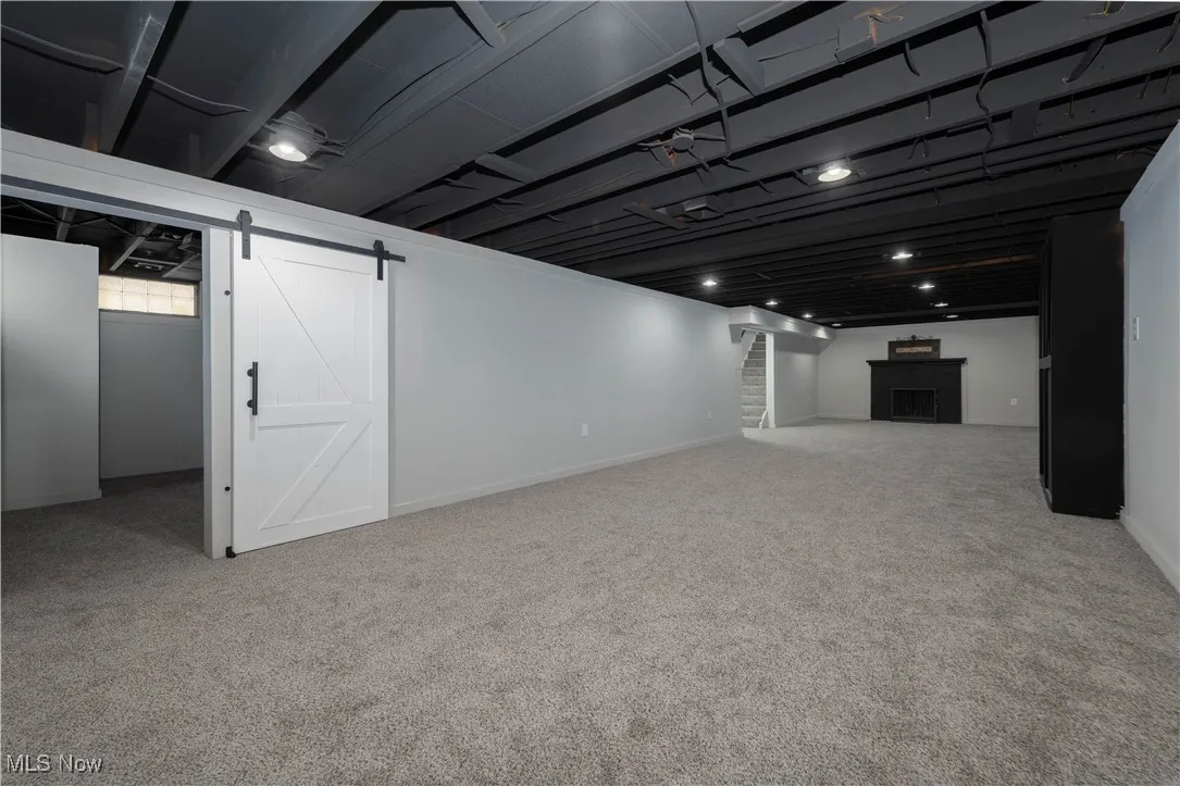 Finished basement with a barn door to possible 4th bdrm