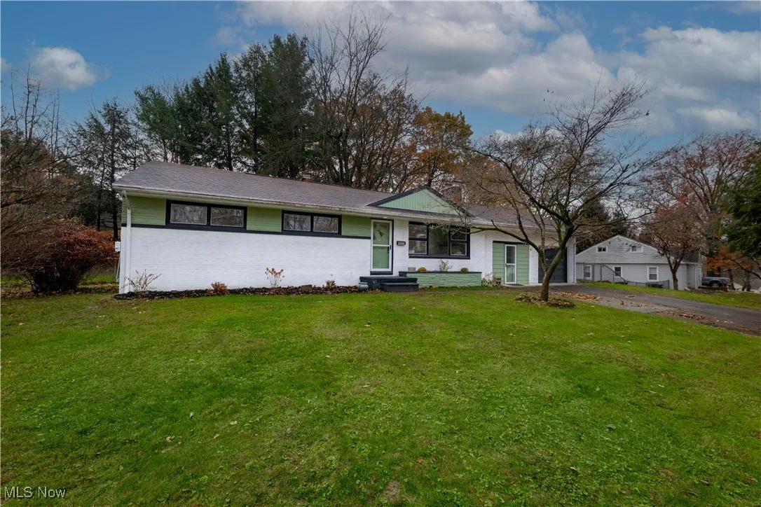 Ranch-style home featuring a front yard & brick siding