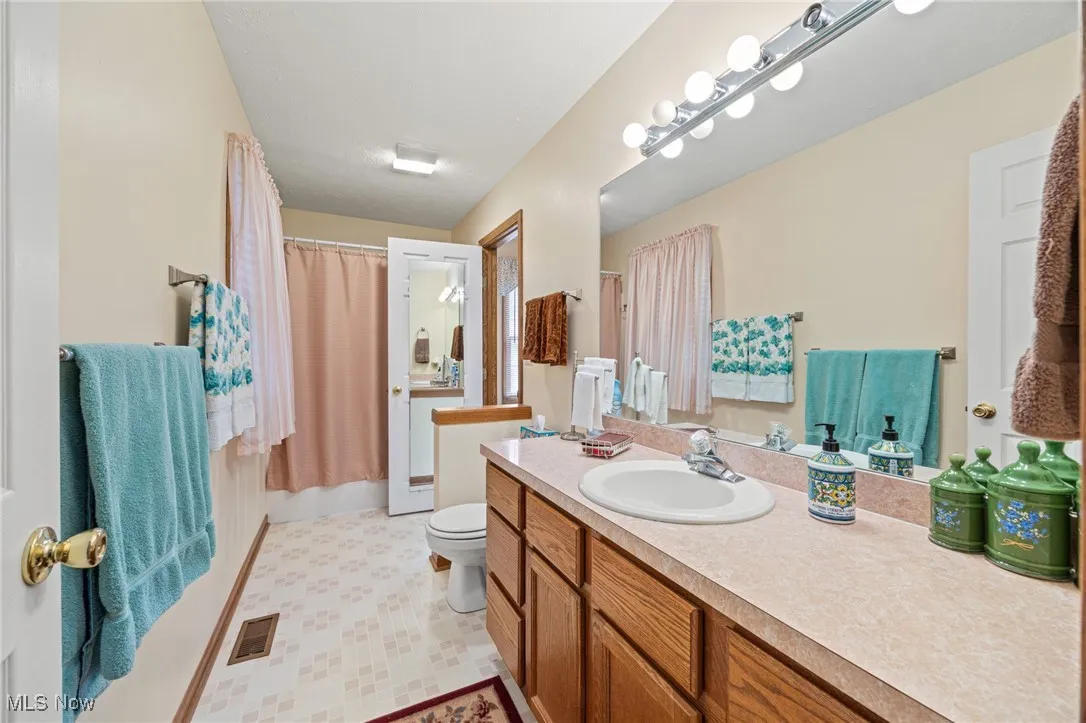 Full bath featuring vanity and light flooring