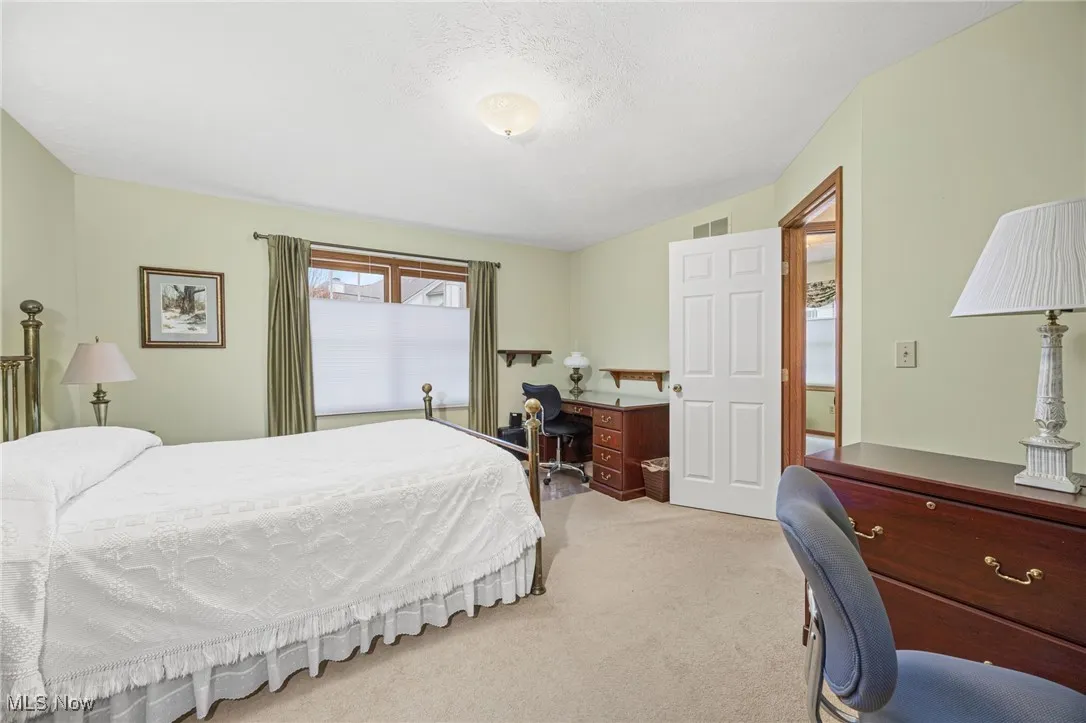 Carpeted bedroom with a desk