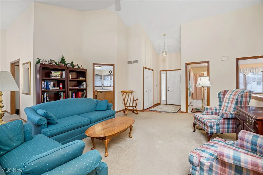 Living area featuring high vaulted ceiling and carpet