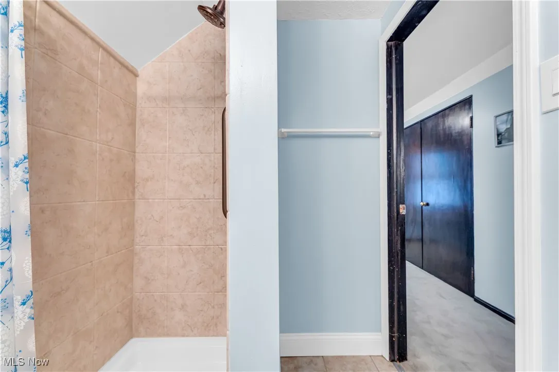 Full bath featuring tiled shower