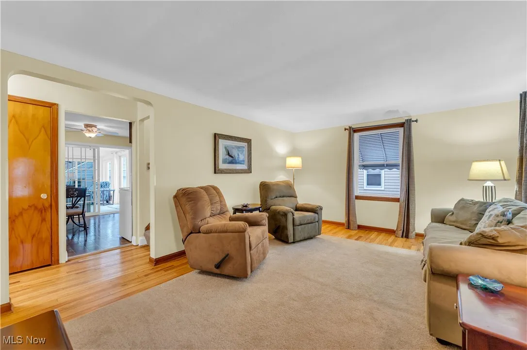 Living room with light wood-style floors and a ceiling fan
