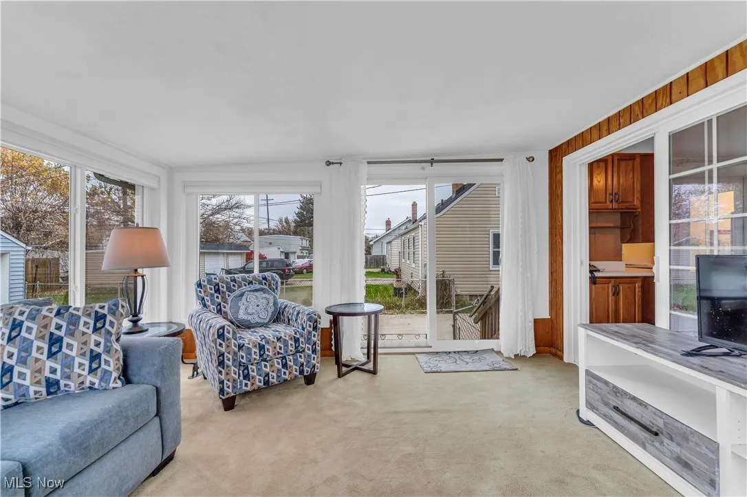 Living area with light carpet and wood walls