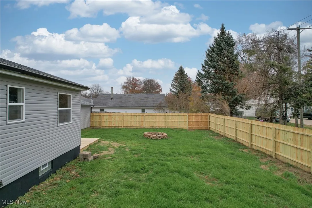 Fenced backyard with a fire pit