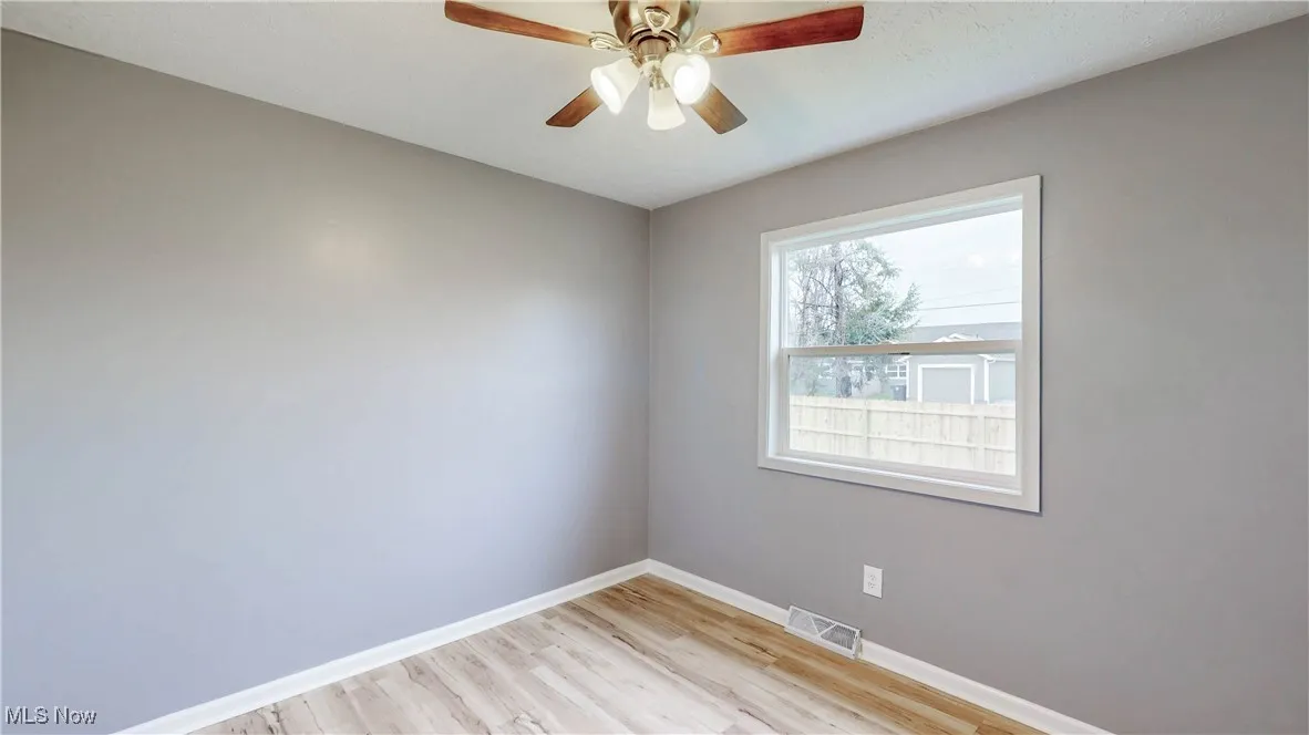 Unfurnished room with light wood finished floors and a ceiling fan