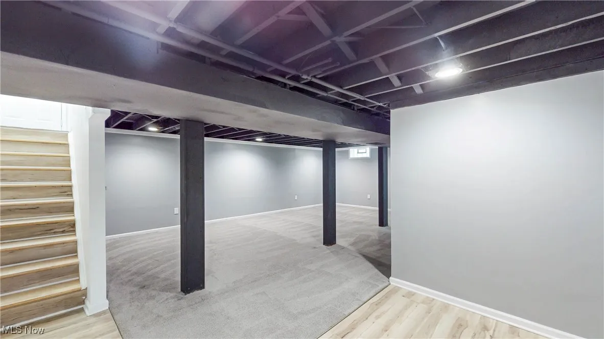 Finished below grade area with stairs and light wood finished floors