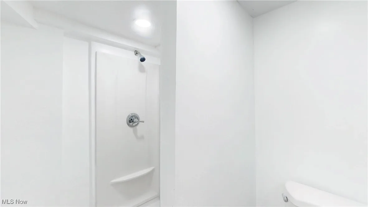 Full bath with toilet and a shower stall