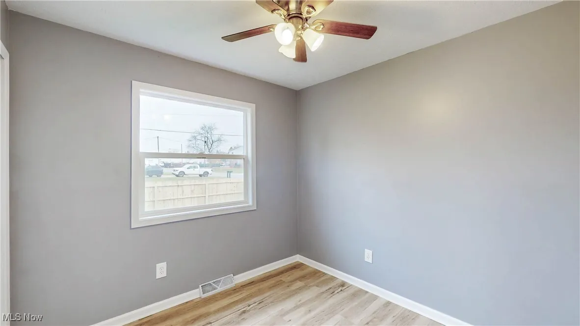 Empty room with light wood finished floors and a ceiling fan