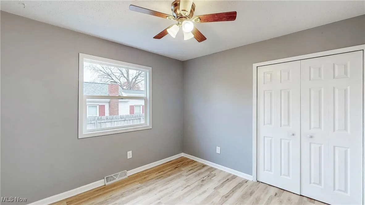 Unfurnished bedroom featuring a closet, light wood-style floors, and ceiling fan