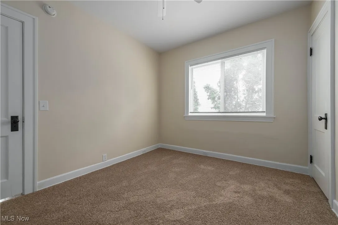Empty room featuring carpet floors and ceiling fan