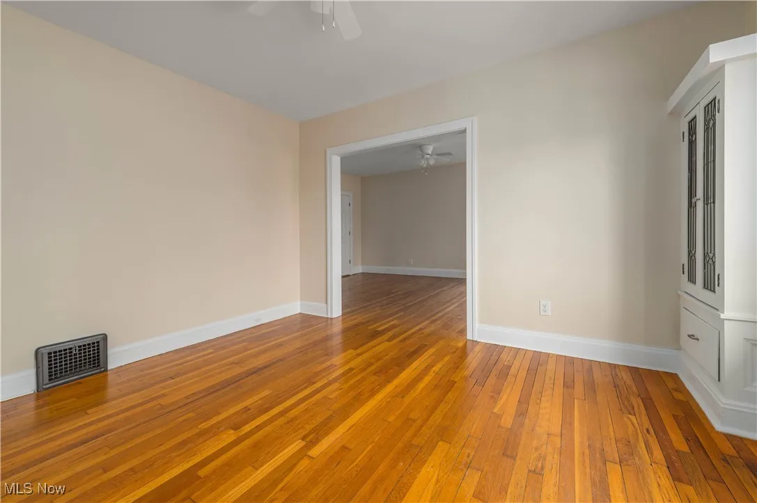 Spare room featuring light wood-style flooring and baseboards