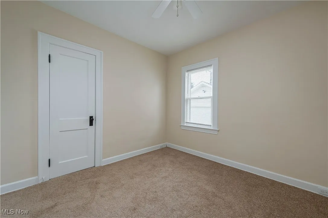 Spare room with baseboards and light carpet