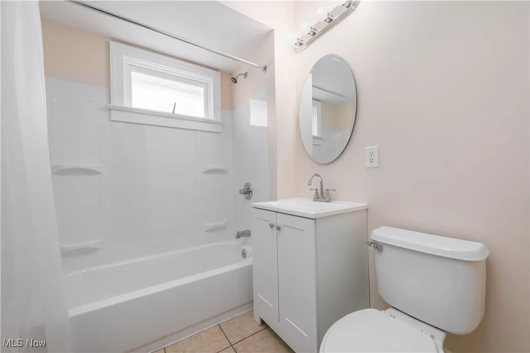 Bathroom featuring shower / bath combo, vanity, and light tile patterned floors