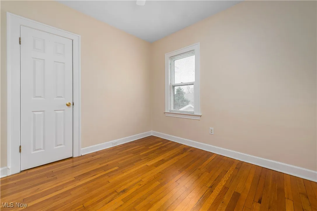 Unfurnished room with baseboards and hardwood / wood-style floors