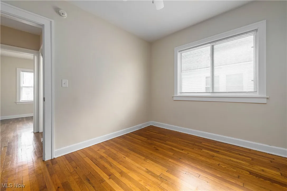 Spare room featuring baseboards and dark wood-style flooring