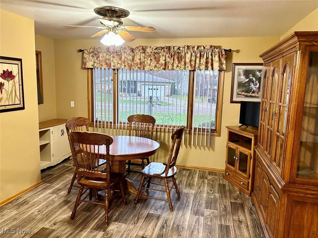 Dining space featuring dark wood-style floors, healthy amount of natural light, and a ceiling fan