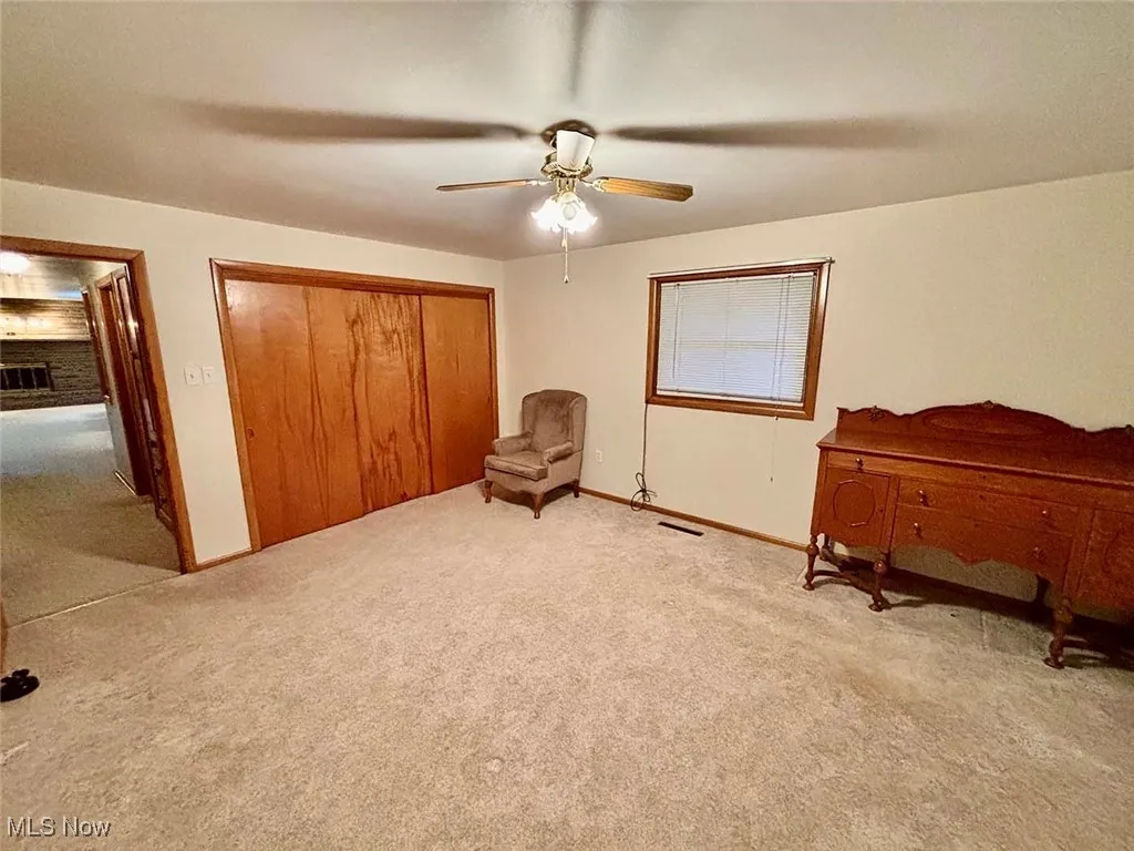 Carpeted primary bedroom with a closet and a ceiling fan