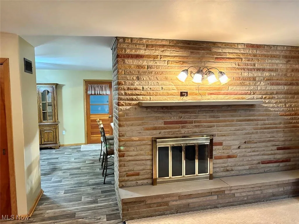 Living room with wood finished floors and a brick fireplace