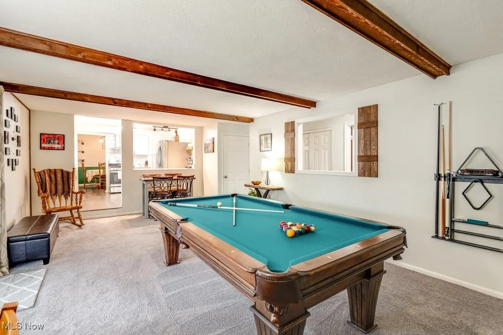 Recreation room with beam ceiling, carpet floors, a textured ceiling, and billiards table
