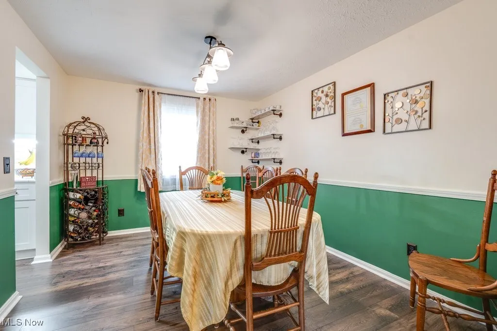Dining space featuring dark wood-style flooring and baseboards