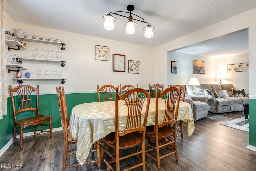Dining room with dark wood-type flooring and a textured ceiling