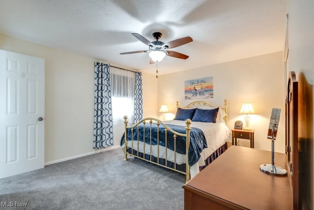 Bedroom featuring carpet floors, a ceiling fan, and a textured ceiling