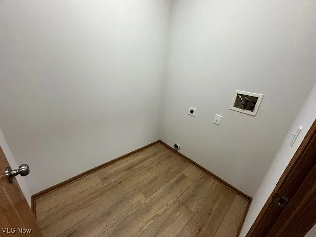 Washroom with hookup for a washing machine, wood finished floors, and hookup for an electric dryer