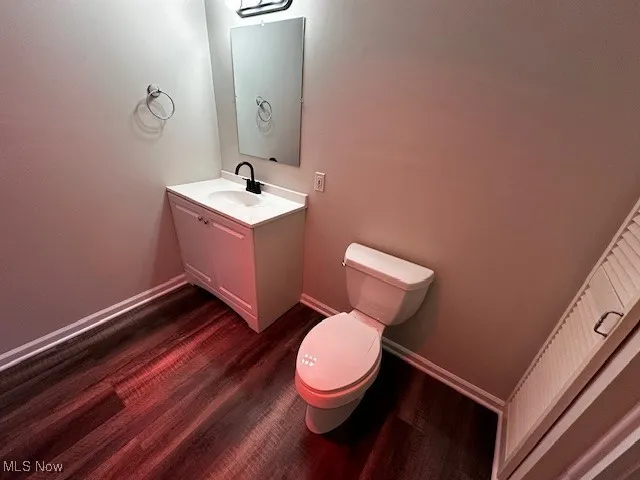 Half bath with vanity and dark wood finished floors