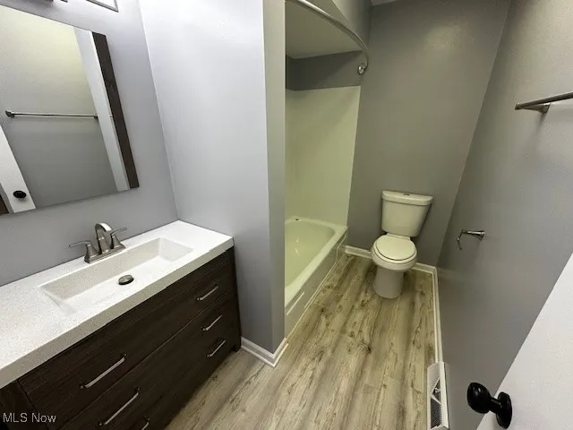 Bathroom featuring vanity, light wood-type flooring, and shower / tub combination