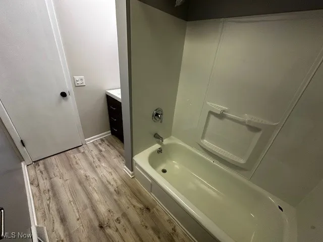 Bathroom featuring vanity, light wood finished floors, and shower / bath combination