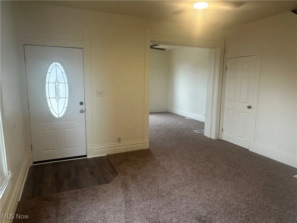Foyer featuring carpet flooring and baseboards