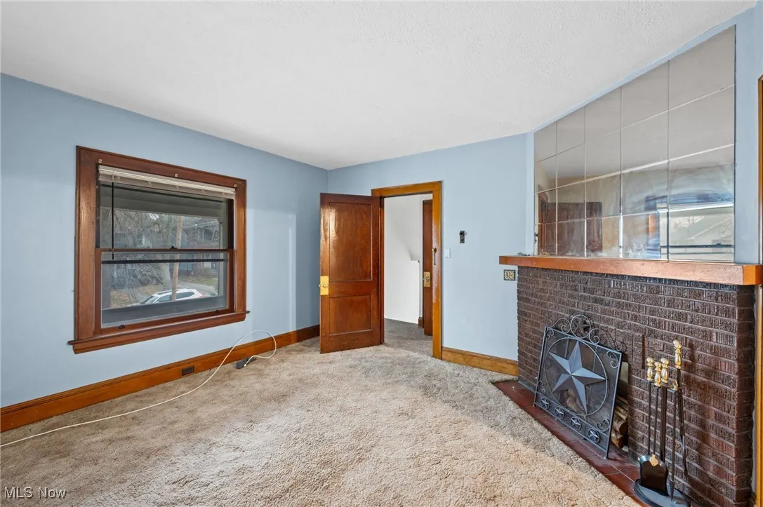 Unfurnished living room featuring carpet, a fireplace, and a textured ceiling